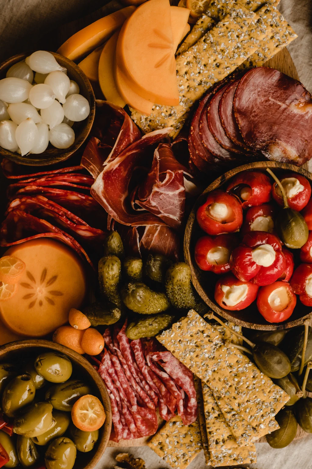 Premium charcuterie spread with cured meats, crackers, olives, and peppers